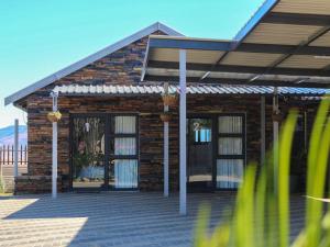 a brick house with glass doors on a patio at Wild Olive Luxury Accommodation in Newcastle