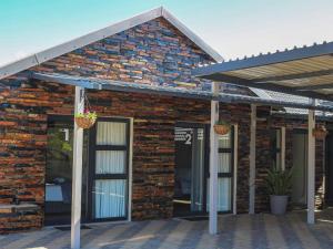 a brick building with awning and doors on it at Wild Olive Luxury Accommodation in Newcastle +7 photos