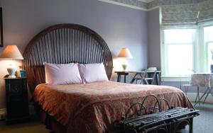 a bedroom with a large bed with a wooden headboard at The Willows Inn in San Francisco