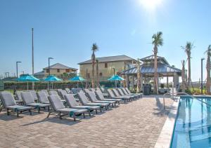 a row of lounge chairs next to a swimming pool at The Oasis at Orange Beach 1611 (Phoenix West II) in Orange Beach