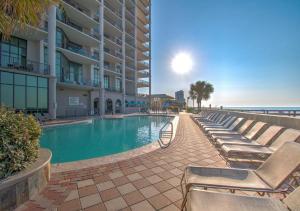 a swimming pool with lounge chairs next to a building at The Oasis at Orange Beach 1611 (Phoenix West II) in Orange Beach