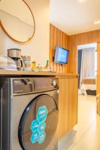 a kitchen with a washing machine in a room at Premium Lago Centro de Atividade do Lago Norte - Torre 2 -316 - Studio Neruda - 12 min da Esplanada - O mais bem avaliado na plataforma - By Hospede Fácil in Brasília