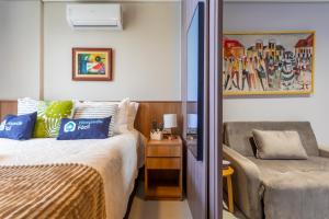 a bedroom with a bed and a chair in it at Premium Lago Centro de Atividade do Lago Norte - Torre 2 -316 - Studio Neruda - 12 min da Esplanada - O mais bem avaliado na plataforma - By Hospede Fácil in Brasília