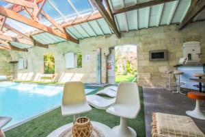 a living room with a pool and two chairs at Gîtes de Gueynard in Gauriaguet