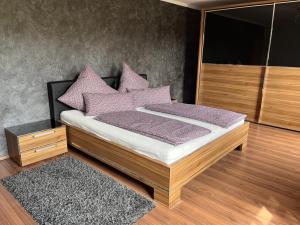 a bedroom with a bed with purple pillows at Ferienwohnung Sonnenblick in Grafenwiesen
