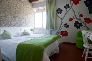 um quarto com uma cama e flores na parede em Izalde em Quejana