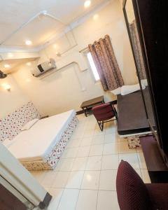 a room with two beds and chairs and a window at hotel bhagwati patel bright in Indore