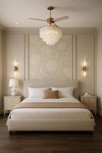 a bedroom with a large white bed with a chandelier at FairMounts Plaza Inns Near Delhi International Airport in New Delhi