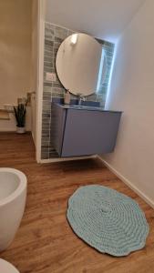 a bathroom with a sink and a mirror and a rug at House 100 meters from the beach in Marina di Ragusa