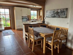 a kitchen with a wooden table and chairs in a room at Ferienwohnung Sonnenblick in Grafenwiesen
