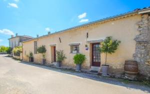 a building with potted plants on the side of a street at Gîtes de Gueynard in Gauriaguet