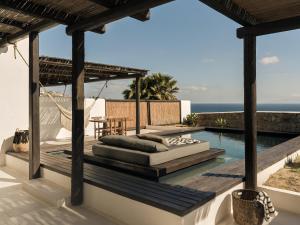 an outdoor patio with a couch and a hammock on a deck at ananea Mykonos - Adults Only in Ornos