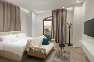 a bedroom with a bed and a chair and a tv at Sleep Inn Apart-Hotel in Cairo +29 photos