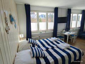 a bedroom with a bed with a blue and white striped blanket at Gryfhaus - Pokój Bosmański, kameralny, 22 m2, parking, Wi-Fi, blisko morza, wysoka ocena 9,9 in Międzyzdroje