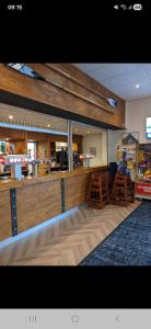 a restaurant with a counter and stools in a room at Highfield Grange Holiday Park in Little Clacton