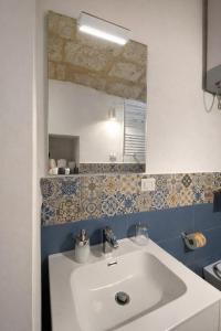 a bathroom with a white sink and a mirror at Bari LandLord 31- Old Town Apartment in Bari +14 photos