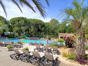 a group of chairs by the pool at a resort at Luxe 6 persoons Chalet camping Leï Suves Cote d'Azur Roquebrune-sur argens in Roquebrune-sur-Argens