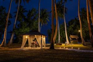 a couple in a gazebo at night with palm trees at Tilar Siro Andamans - A CGH Earth Experience in Havelock Island