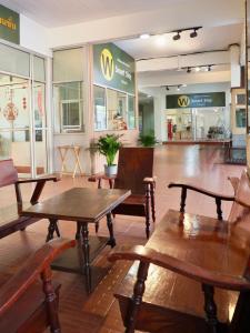 a restaurant with wooden tables and chairs in a store at W Smart Stay TRANG in Trang
