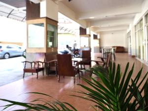 a restaurant with tables and chairs and a plant at W Smart Stay TRANG in Trang