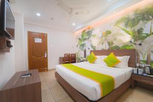 a bedroom with a large bed with a painting on the wall at Hotel Apsara in Kizhake Chālakudi