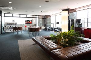 - un salon avec un canapé, une table et des chaises dans l'établissement Hotel Wing International Sagamihara, à Sagamihara