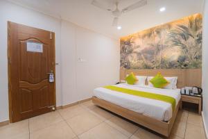 a bedroom with a bed with a large painting on the wall at Hotel Apsara in Kizhake Chālakudi