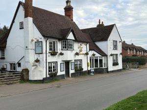 a white building on the side of a street at Silsoe Cottage B&B - Woodland View Room in Silsoe