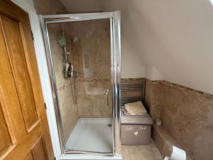 a shower with a glass door in a bathroom at Silsoe Cottage B&B - Woodland View Room in Silsoe +33 photos