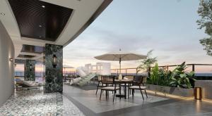a patio with a table and chairs and an umbrella at Phoenix Crowne Vinh Hotel in Vinh