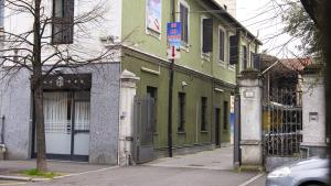 a green building on the side of a street at Bed Rho Stazione - Fiera in Rho