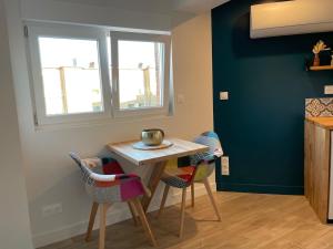 a small kitchen with a table and chairs at Studio cosy avec balcon in Dunkerque +8 photos