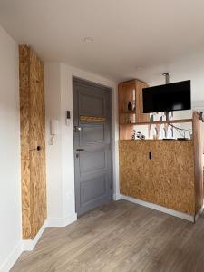 a room with a kitchen with a counter and a door at Studio cosy avec balcon in Dunkerque