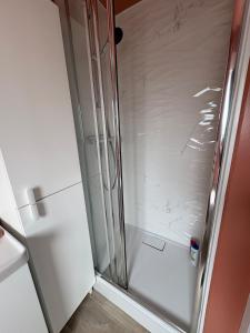 a shower with a glass door in a bathroom at Studio cosy avec balcon in Dunkerque