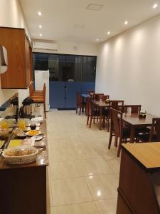 a kitchen and dining room with tables and chairs at AL&V Hotel in Santa Tereza do Oeste