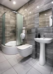 a bathroom with a toilet and a sink and a tub at Hostel Kamienica Rynek 7 in Katowice +27 photos