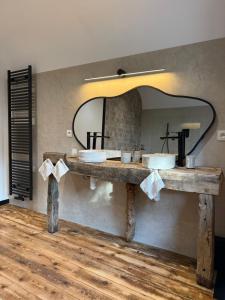 a bathroom with two sinks and a large mirror at La fagnette in Jalhay +11 photos