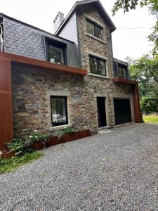 a stone house with a large driveway at La fagnette in Jalhay