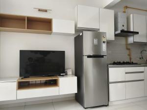 a kitchen with a stainless steel refrigerator and a tv at 1 BHK apartment in Bangalore