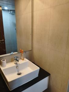 a bathroom with a white sink and a mirror at 1 BHK apartment in Bangalore +11 photos