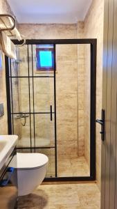 a bathroom with a shower with a toilet and a sink at Feli Eski Datca Adult Only in Datca