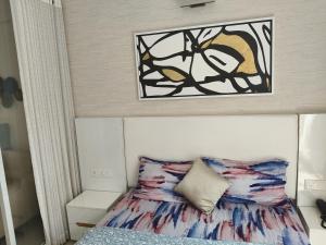 a bedroom with a bed with a painting on the wall at 1 BHK apartment in Bangalore