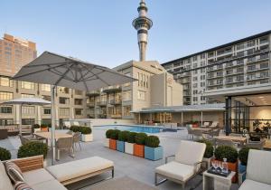 an outdoor patio with tables and chairs and an umbrella at Central Corporate Character in Auckland