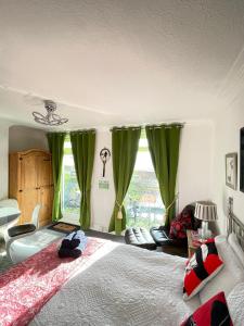 a bedroom with a large bed with green curtains at "The Celebration" Balcony Seafront Apartment in Eastbourne