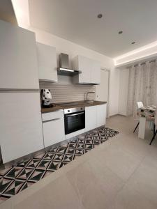 a kitchen with white cabinets and a sink and a table at Lo duca luxury home in Cefalù