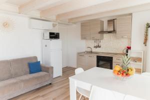 a kitchen and living room with a couch and a table at Villa AMARE in Caorle