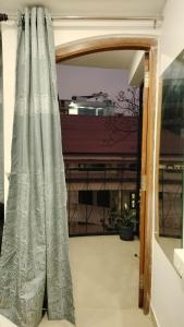 an open door to a balcony with a curtain at RKS Homestay Anex in Shillong
