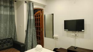 a room with a tv and a couch and a window at RKS Homestay Anex in Shillong +27 photos