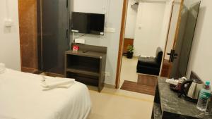 a hotel room with a bed and a television at RKS Homestay Anex in Shillong