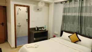 a bedroom with a white bed and a shower at RKS Homestay Anex in Shillong